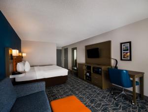 a hotel room with a bed and a desk and a tv at Comfort Inn Falls Church - Tysons Corner in Falls Church