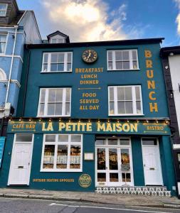 a blue building with a sign on the side of it at La Petite Maison Apartments in Brixham