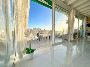 a white room with a table and a view of the ocean at Penthouse of Views Los Cristianos in Los Cristianos