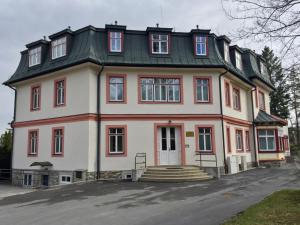 a large white house with a gambrel roof at Stará Morava Apartmán Zuzka, Tatranská Lomnica in Vysoke Tatry - Tatranska Lomnica.