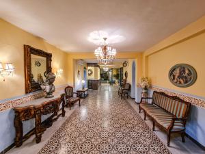 a hallway with chairs and a chandelier at Hotel Fundadores in Valladolid