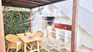 een patio met een houten tafel en stoelen bij VILLA LORENZo in Cala Blanca