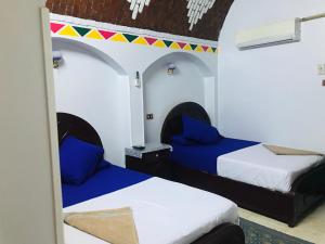 two beds in a room with blue and white at Gamal Robob Nubian Guest House in Aswan +37 photos