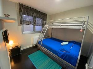 una camera con letto a castello e letto blu di Apartamento de playa familiar, piscina y garaje. a Ares