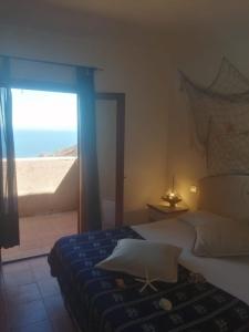 a bedroom with a bed and a view of the beach at Villetta Susy in Costa Paradiso