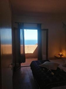 Schlafzimmer mit einem Fenster mit Meerblick in der Unterkunft Villetta Susy in Costa Paradiso
