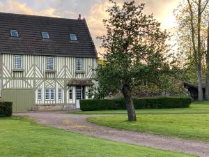 une maison avec un arbre en face dans l'établissement Gîte de charme à la campagne, à Troarn