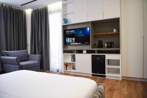a hotel room with a bed and a tv at The Wilson Tirana in Tirana