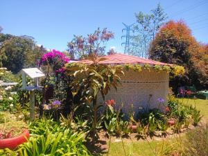 a monument in a garden with flowers at Hospedaje Santaelena -chalets de montaña- in Santa Elena
