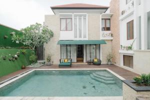 a house with a swimming pool in front of a house at Villa Maisha by The Lavana in Nusa Dua