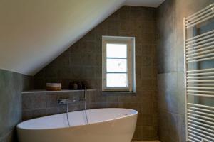 a bathroom with a tub and a window at Forsthaus Nauen in Nauen