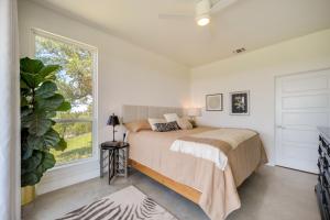 Un dormitorio con una cama y una ventana grande. en Chic House in Spring Branch with Lush Outdoor Space!, en Spring Branch