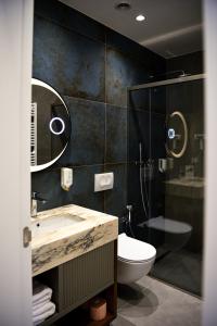a bathroom with a sink and a toilet and a shower at The Wilson Tirana in Tirana