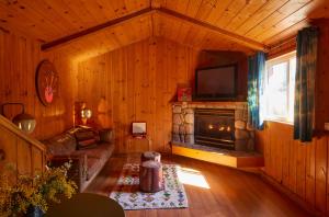 a living room with a fireplace and a tv at Ojai Rancho Inn in Ojai