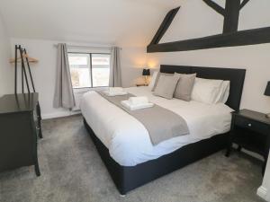 a bedroom with a large white bed with a window at Kennedy's Cottage in Ashbourne
