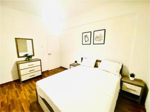 ein Schlafzimmer mit einem großen weißen Bett und einem Spiegel in der Unterkunft CHADI APARTMENT in Larnaka