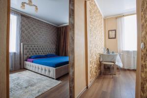 1 dormitorio con cama y espejo en 1-комнатная квартира в центре на Аль-Фараби 93 en Kostanái