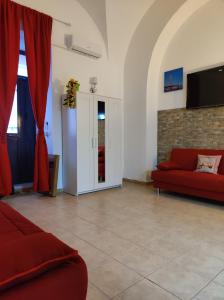 a living room with a red couch and a tv at Robert holiday apartment in Catania