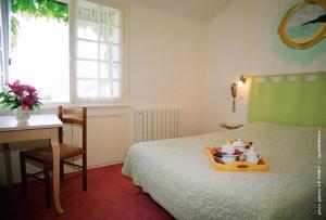- une chambre avec un lit, une table et un bureau dans l'établissement Hotel Men Er Vro, à Quiberon