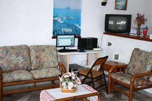 a living room with a couch and a desk with a computer at Hotel Rea in Naxos Chora