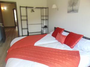 Una cama con almohadas rojas encima. en Hotel El Mirador del Nalon, en San Román