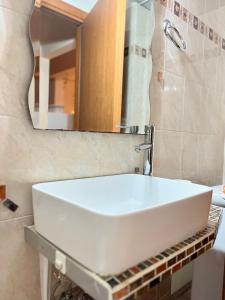 um lavatório branco na casa de banho com um espelho em Dimitri's House em Nafplio