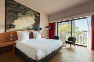 烏特勒支的住宿－Leonardo Hotel Utrecht City Center，卧室配有一张床,并有一幅女子大画