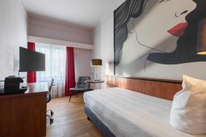 ein Hotelzimmer mit einem Bett und einem Gemälde einer Frau in der Unterkunft Leonardo Hotel Utrecht City Center in Utrecht