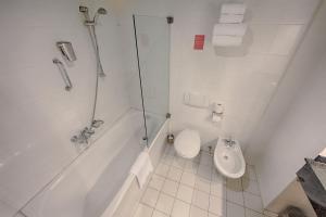 ein Badezimmer mit einer Badewanne, einem WC und einem Waschbecken in der Unterkunft Leonardo Hotel Utrecht City Center in Utrecht
