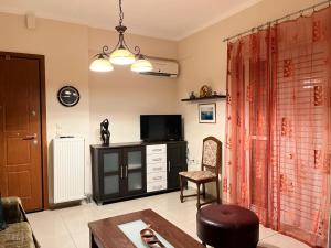 un soggiorno con TV, tavolo e sedia di Dimitri's House a Nauplia