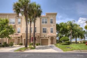 a large house with palm trees in front of it at Spacious Vista Cay Townhome Newly Furnished in Orlando