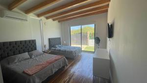 1 dormitorio con 1 cama, TV y ventana en VILLA KITE Habitaciones cuadruples LUJO , SALINAS DEL REY en Juan de Acosta