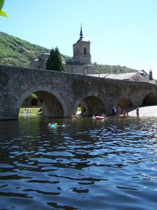 un grupo de personas nadando en el agua bajo un puente en La Lechería en Val de San Lorenzo