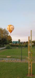 a hot air balloon flying over a field at Wakacyjny domek Marcel in Duszniki Zdrój