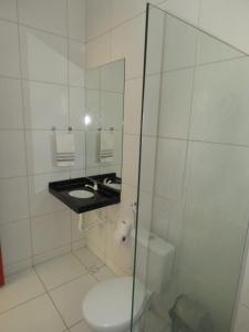La salle de bains est pourvue de toilettes et d'une douche en verre. dans l'établissement Casa Mar e Dunas, à Icaraí