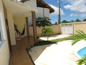 une arrière-cour avec une piscine et une maison dans l'établissement Casa Mar e Dunas, à Icaraí