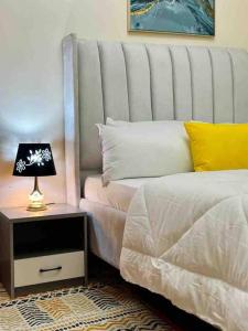 1 dormitorio con cama y mesita de noche con lámpara en Vob cosy home, en Eldoret