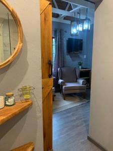 vista su un soggiorno con sedia e specchio di Greenwood Lea Cottage - luxury, romantic cottage a Hilton