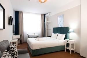 pokój hotelowy z łóżkiem i oknem w obiekcie City Plaza Apartments & Rooms w Salonikach