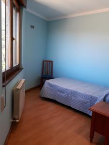 リャネスにあるLlanes-Llumedianのベッドと椅子と窓のある寝室