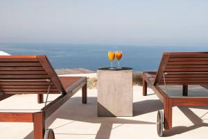 two chairs and a table with two glasses of wine at Dreamy Cycladic Summer House 3 in Serifos Chora