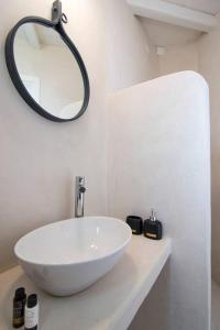 y baño con lavabo blanco y espejo. en Dreamy Cycladic Summer House 3, en Serifos Chora