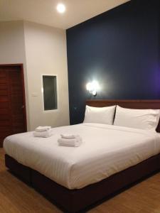 a bedroom with a large bed with two towels on it at Bird Day Boutique Hotel in Mukdahan