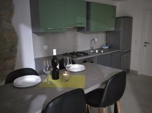a kitchen with a table with two glasses of wine at Apartman Lari in Vižinada