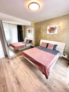 um quarto com uma cama grande e um espelho em Mega Rossa Residence em Bucareste