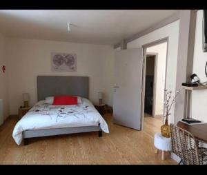 - une chambre avec un lit et un oreiller rouge dans l'établissement Auberge du Pont, à Saint-Projet-de-Salers