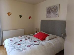 - une chambre avec un lit et un oreiller rouge dans l'établissement Auberge du Pont, à Saint-Projet-de-Salers