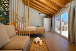 Habitación con cama, sofá y ventana en Sea & Cliff Luxury Suites en Benitses