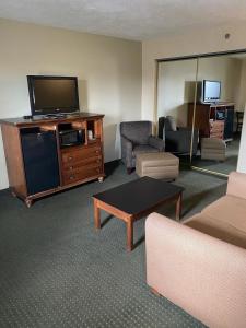 a living room with a tv and a couch and a table at The Boardwalk Inn in Branson