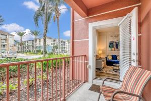uma varanda com uma cadeira e uma sala de estar em Ground-floor condo next to Vista Cay Clubhouse and pool! em Orlando